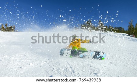 Dynamic action snowboarding, 16x9 wide screen photo. Snowboard boy spraying snow into camera. Best photo for banner Royalty-Free Stock Photo #769439938
