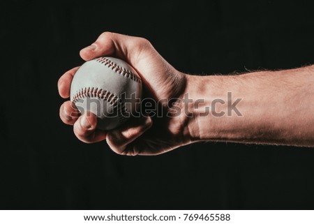 cropped shot of male hand holding baseball ball isolated on black  