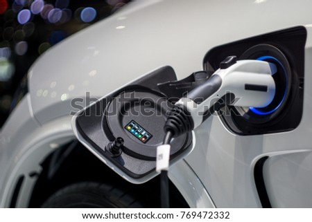 Close up of the Hybrid car electric charger station with power supply plugged into an electric car being charged. Royalty-Free Stock Photo #769472332