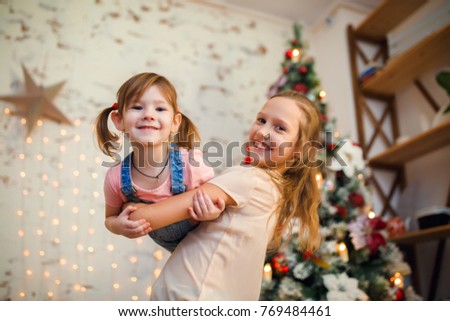 Photo of two sisters in background of New Year's decorations