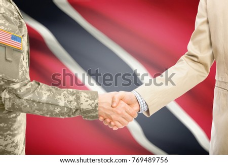 American soldier in uniform and civil man in suit shaking hands with adequate national flag on background - Trinidad and Tobago