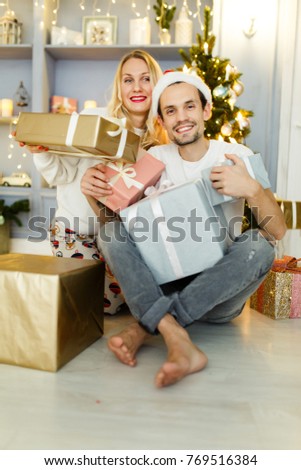 Photo of man and woman in Santa hat with gift in box