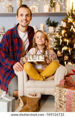 Photo of father and girl with gift background of Christmas decorations in studio