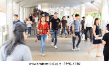 Blur crowd of anonymous people walking on bridge to work place in morning rush hours