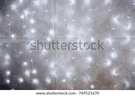 Concrete wall with a garland of lights. New Year's background.