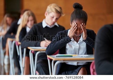Anxious Teenage Student Sitting Examination In School Hall Royalty-Free Stock Photo #769528084
