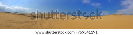 Panorama picture - Sand dune with blue sky and cloud at Tottori , Japan.