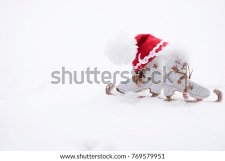 Winter holidays background:  wooden made skates and Santa Claus hat. Closeup