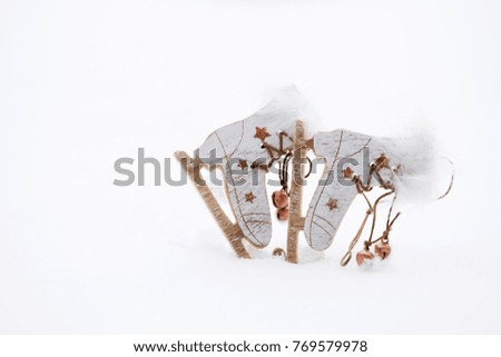 Winter holidays background:  wooden made skates in the snow. Closeup