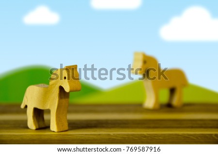 Eco wooden horses on cartoon landscape background. Silhouette of a toys cuted from wood.