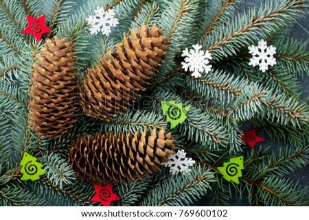 Christmas or New Year background. Big branch of fit-tree with cones, wooden toys and snowflakes. Selective focus.Top view.