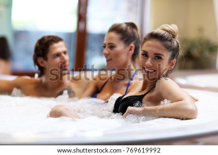 Picture showing group of friends enjoying jacuzzi in hotel spa