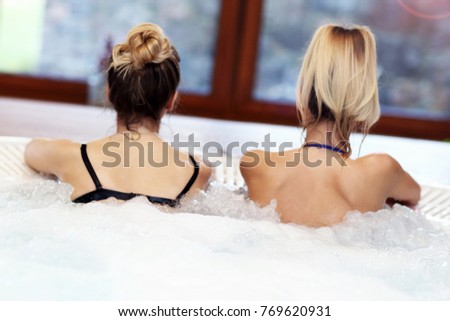 Picture showing happy girl friends enjoying jacuzzi in hotel spa