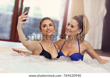 Picture showing happy girl friends enjoying jacuzzi in hotel spa