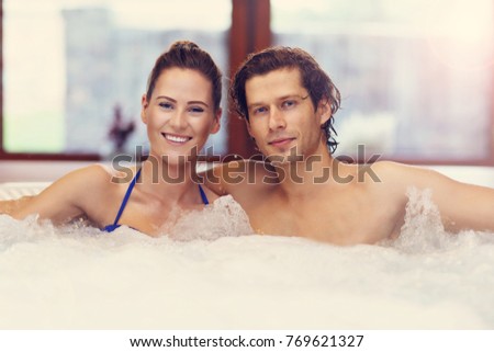Picture showing young couple enjoying jacuzzi in hotel spa