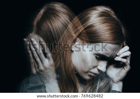 Young red haired female with mood disorder crying and having a headache Royalty-Free Stock Photo #769628482