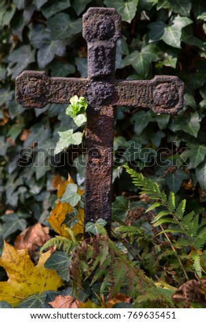 Old rusty memorial cross at cemetery. Religious Christian symbol