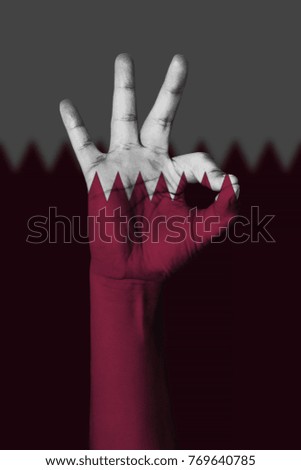 Hand making Ok sign, Qatar flag painted as symbol of best quality, positivity and success - isolated on flag background