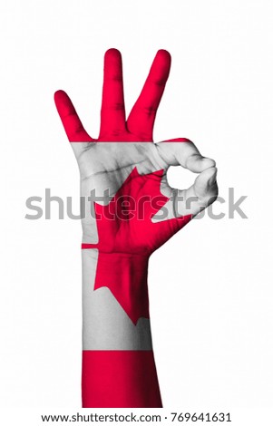 Hand making Ok sign, Canada flag painted as symbol of best quality, positivity and success - isolated on white background