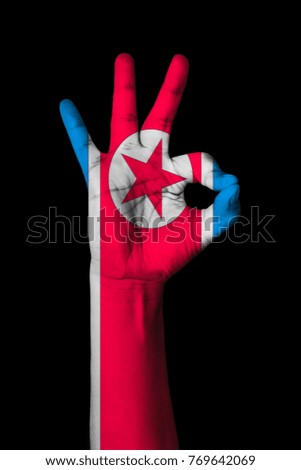 Hand making Ok sign, Korea north flag painted as symbol of best quality, positivity and success - isolated on black background