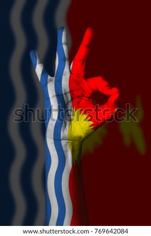 Hand making Ok sign, Kiribati flag painted as symbol of best quality, positivity and success - isolated on flag background
