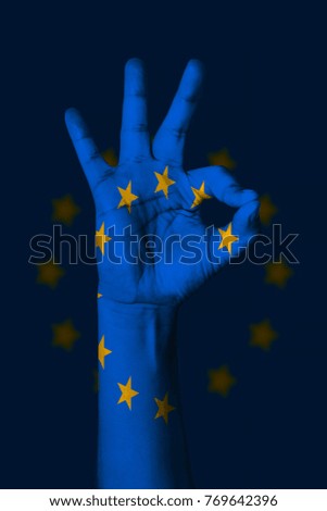 Hand making Ok sign, Europe flag painted as symbol of best quality, positivity and success - isolated on flag background