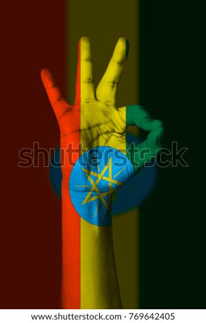 Hand making Ok sign, Ethiopia flag painted as symbol of best quality, positivity and success - isolated on flag background