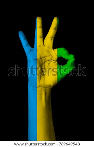 Hand making Ok sign, Gabon flag painted as symbol of best quality, positivity and success - isolated on black background