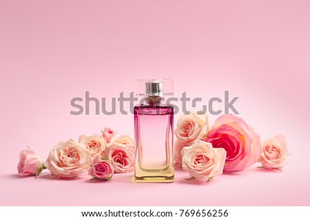 Bottle of perfume with flowers on color background Royalty-Free Stock Photo #769656256