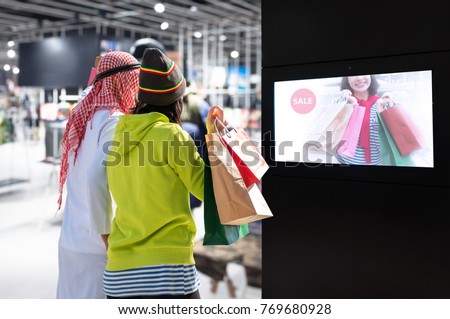 Intelligent Digital Signage , Augmented reality marketing and face recognition concept. Interactive artificial intelligence digital advertisement and customer shopping in fashion retail shopping Mall.