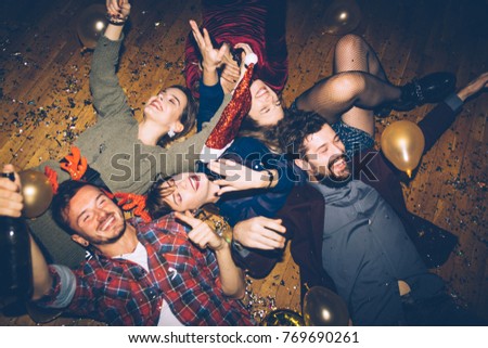 Group of friends having fun on a floor, celebrating New Year