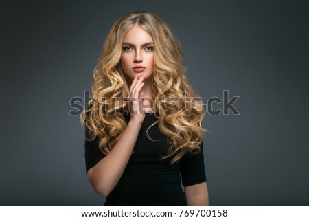 Curly long hair blonde young model. Beauty girl with curly perfect hairstyle
