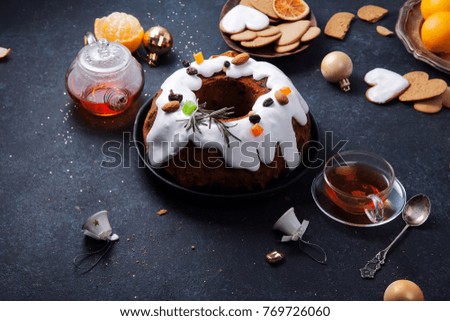 Traditional christmas cake with dried fruits soaked in rum and sugar glaze. Teatime with heart-shaped ginger cookies. Christmas background with festive decoration. Horizontal composition