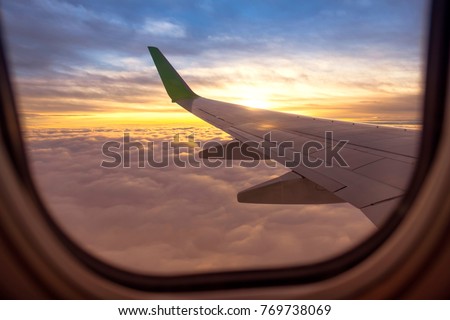 look beautiful sky and Airplane wing on Airplane beside windows with sunrise light Royalty-Free Stock Photo #769738069