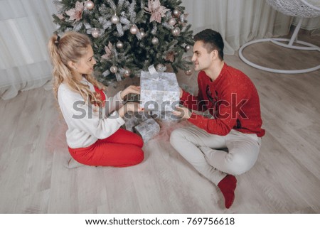 loving couple decorating the christmas tree unwrapping presents and enjoying the holidays