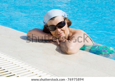 adult women get sunbathes in the pool
