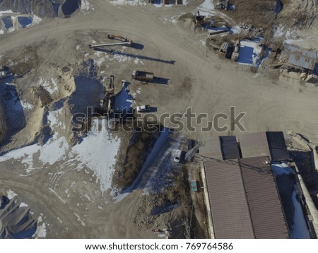aerial view of a quarry, work in progress, signage, containers, buildings