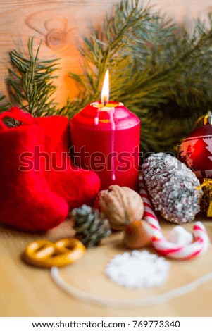 Christmas toys, lighted candles, fir cones, snowflakes, wooden background, fresh pine branches. Greeting card, holiday concept.