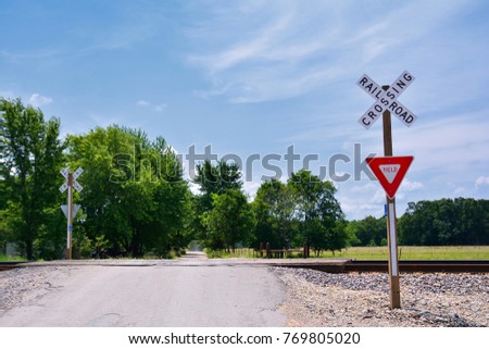 Railroad crossing sign against blue sky background, with space for your text.
