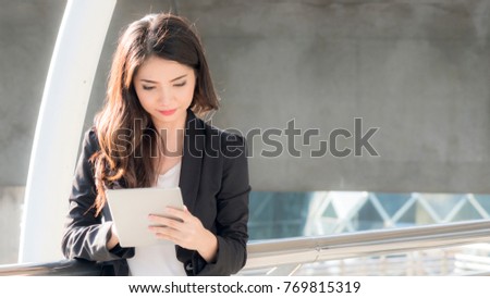 business girl with smart tablet devices and city background