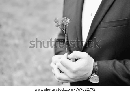 groom holds a flower