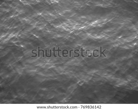 Black and white water surface of Oman's Sea under the rays of sun in twilight. Background and Texture
