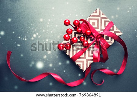 Holidays gift box with red bow over dark background