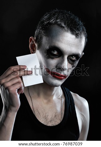 Spooky man on hold empty paper on black background