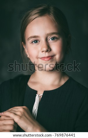 Close-up portrait of a cute ten-year-old girl smiling at camera.