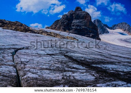view from a blank glacier on the dachstein plateau towards the summit of the dachstein mountain, the highest mountain in styria and upper austria with a high mountain ridge and summits in the austria