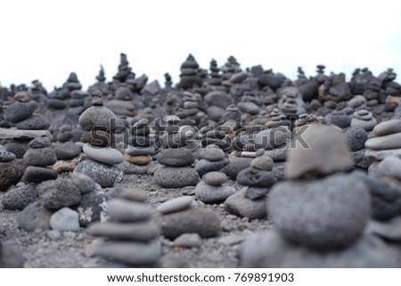 Balanced stone pyramid on sea shore, waves in background