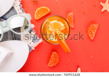 Summer vacation. Orange fruit cocktail, detox water near white flip flops, shorts and sunglases