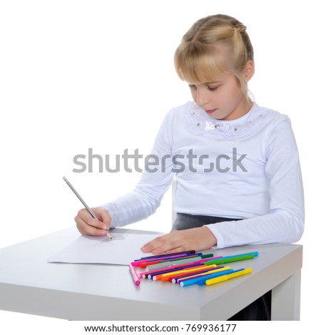 A little girl draws at a table on a piece of paper. The concept of a happy childhood, creativity, learning in school and family. Isolated on white background.