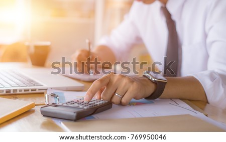 Businessman accountant using calculator and laptop for calculating finance on desk office. business financial accounting concept. Royalty-Free Stock Photo #769950046